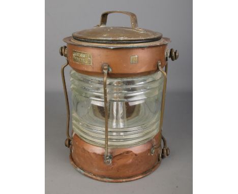 A copper and brass bodied Meteorite ships light; P120764, with ribbed glass shade. Stamped 'L'. 33cm tall.  Has been electric