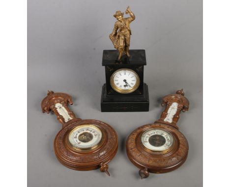 A slate mantle clock decorated with gilt figure of a young boy along with two barometers.  