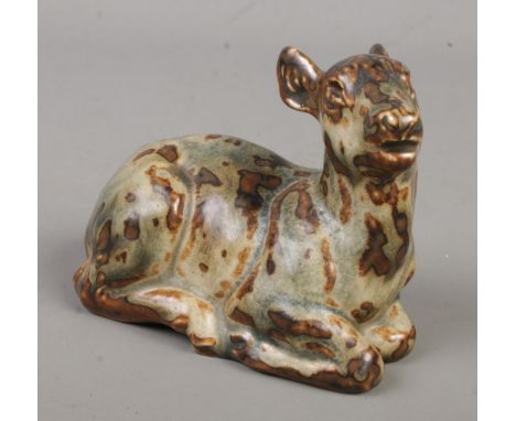 An early Royal Copenhagen stoneware figure formed as a recumbent deer. Possibly by Knud Kyhn. Having impressed model number t