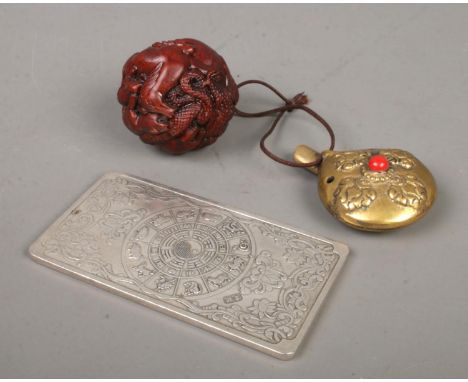 A small collection of Oriental items. Includes Chinese white metal Zodiac ingot, spherical netsuke depicting the twelve anima