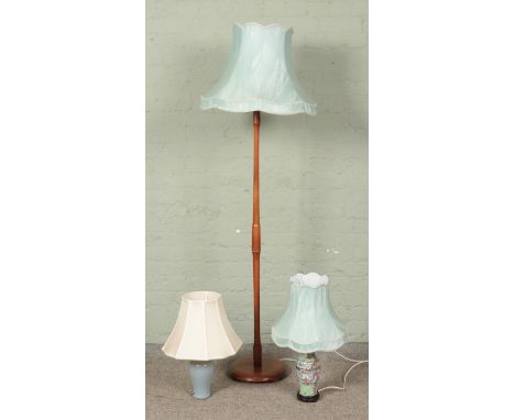 A wooden turned standard lamp, together with two ceramic table lamps.  