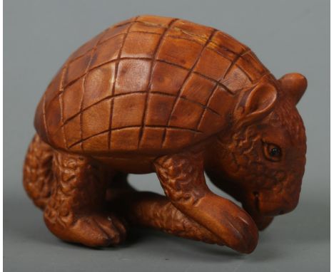 A hand carved hardwood netsuke of a pangolin, signed to base.  