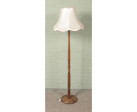 A turned wooden standard lamp with shade.  