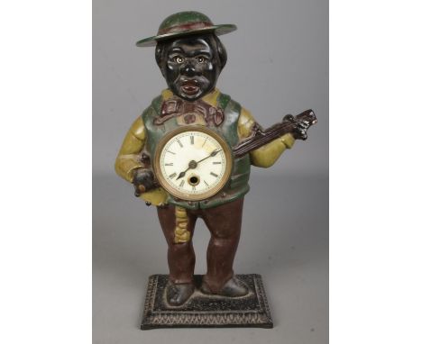 A painted cast iron novelty figural mantel clock formed as a gentleman playing the banjo. Possibly American (39cm)  