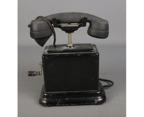 A 1930's hand crank desk phone with bakelite phone and metal body.  