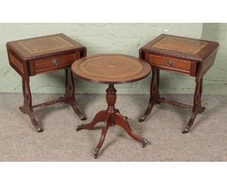 A pair of mahogany sofa tables with lyre supports and leather inset tops along with a matching circular side table.  One cast