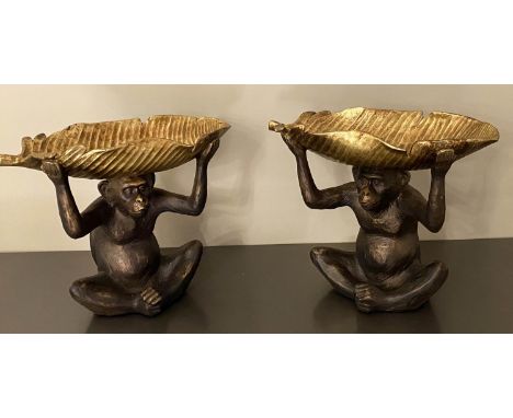 SERVING DISHES, each in the form of a monkey holding a gilt leaf, 33cm high, 40cm wide, 18cm d, faux bronze. 