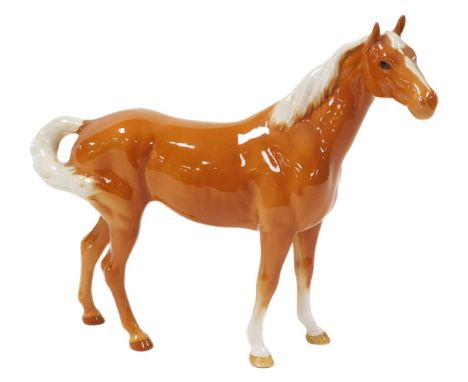 A Beswick figure of a Palomino horse, printed mark, 26cm wide.