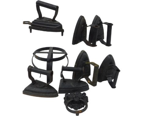 Seven Victorian cast flat irons, together with an iron stand, and a cast iron lion's head and ring door knocker. (7)