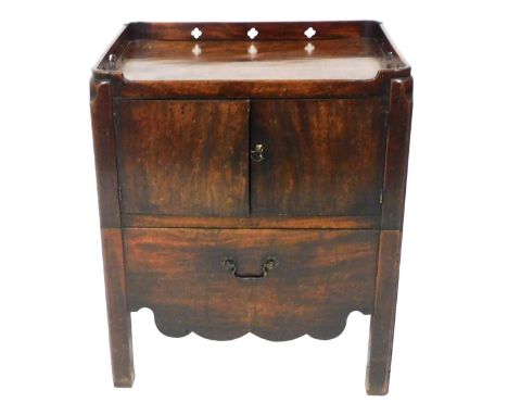 A George III mahogany night commode, the rectangular top with pierced handles and decoration, above two doors and drawer with