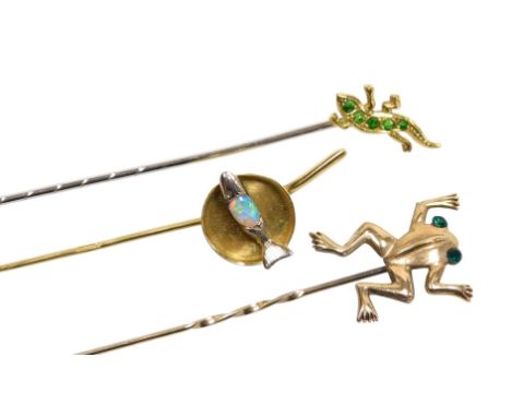 A demantoid garnet set stick pin, modelled as a newt, fire opal set stick pin modelled as a fish in a pan, in white and yello