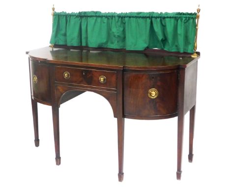 A George III mahogany breakfront sideboard, with a brass framed and fabric back, central frieze drawer flanked by a cupboard 
