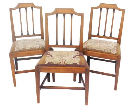 A set of four Edwardian mahogany and inlaid dining chairs, with a triple column back, and drop in tapestry seats, raised on s