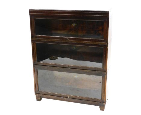 A Globe Wernicke mahogany three tier sectional bookcase, with glazed doors on block feet, printed labels to interior, 110cm h