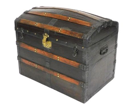 A late 19th/early 20thC canvas and stained wooden bound trunk, the hinged dome top revealing an interior with striped paper f