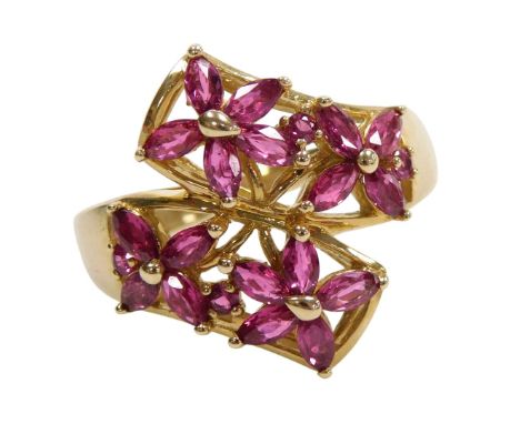 A 9ct gold and ruby four flowerhead ring, in a curved two row design, size S, 4.8g.