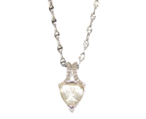 A 9ct white gold and white topaz pendant, the trilliant cut stone set in a claw mount with scroll suspension set with tiny di