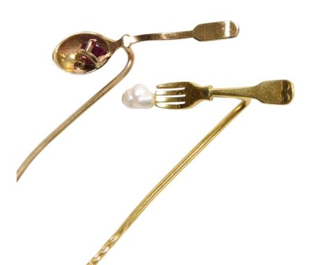 A gold and seed pearl tie pin formed as a fork and morsel, hallmark worn, and a ruby set tie pin, formed as a spoon and morse