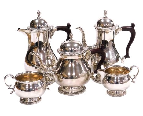 An Elizabeth II silver five piece tea and coffee set, of baluster form, with leaf scroll embossed spouts, and gadrooned lid a
