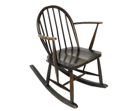A mid century Ercol beech and elm rocking chair, stamped no. F182/290, bears a blue Ercol sticker to the underside of the sea