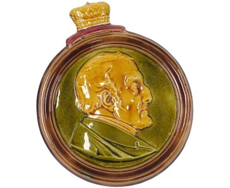 An early 19thC pottery memorial plaque to the Duke of Wellington, showing a bust portrait, within a circular frame, and crown