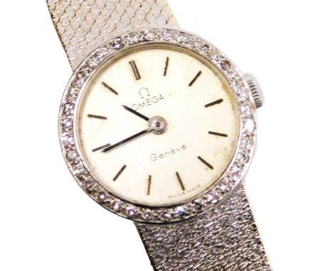 An Omega 18ct white gold and diamond lady's wristwatch, circular silvered dial with batons, the bezel set with brilliant cut 