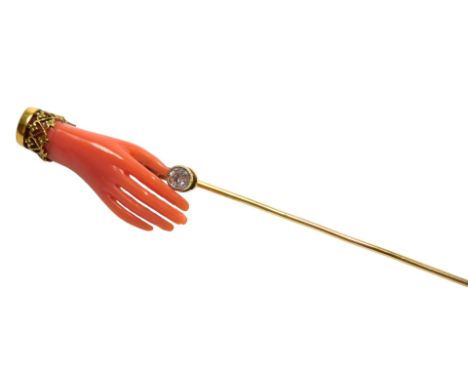 A Victorian coral and diamond tie pin, formed as a hand, in yellow metal, 2.5g.