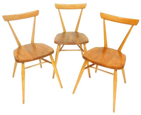 A set of three light beech and elm Ercol dining chairs, each with a tapering back and a solid seat, stamped to underside pate