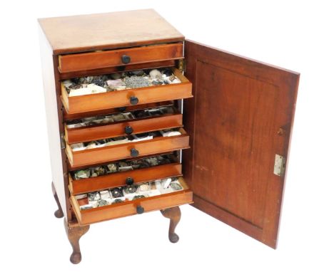An early 20thC mahogany collector's chest, the panel door opening to reveal thirteen drawers, eleven containing mineral speci
