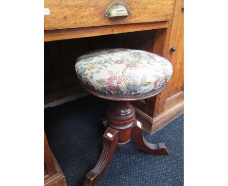 A Victorian walnut circular swivel top piano stool having later tapestry upholstery
