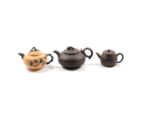 Three Chinese redware teapots and two porcelain teapots, the largest; of squat form with concentric bands, seal mark to under