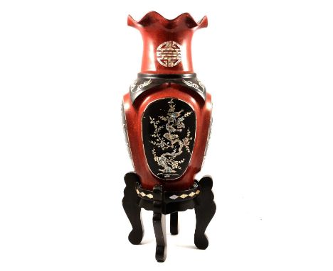 Modern Oriental lacquered vase, inlaid panels with mother of pearl, raised on a carved wood stand, overall height 54cm.
