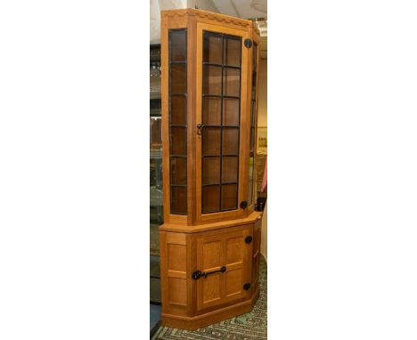 Workshop of Robert 'Mouseman' Thompson  - A large glazed oak corner display cabinet, upper section with leaded glazed door. O