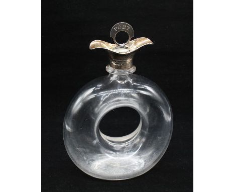 Hukin & Heath - A George V stylish silver collared glass decanter, of circular form with Tyre like circular hole to centre. N