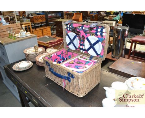 A wicker picnic hamper and contents