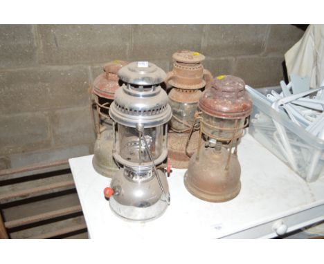 Two Tilley lamps, one other paraffin lamp and a hurricane lamp