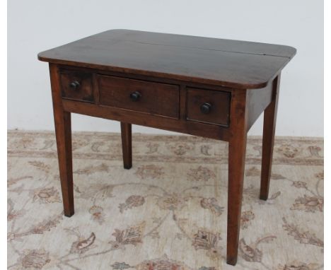 An 18th century oak side table, the planked top with rounded corners above three drawers on square tapering legs, 93.5cm wide