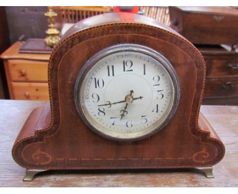 An Edwardian mahogany mantle clock, with a circular dial and Arabic numerals on brass feet
