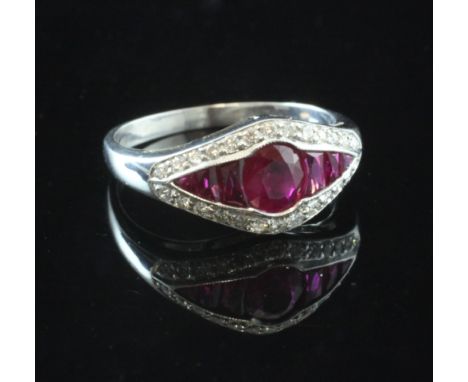 A white gold, ruby and diamond elliptical shaped ring, the central oval cut ruby flanked by six graduated shaped cut rubies a