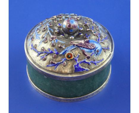 A 20th century Chinese silver and enamel mounted green hardstone circular box and cover, the lid with ball finial and decorat