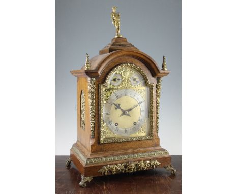 An early 20th century ormolu mounted oak bracket clock, of architectural form with arched brass dial and W & H movement chimi