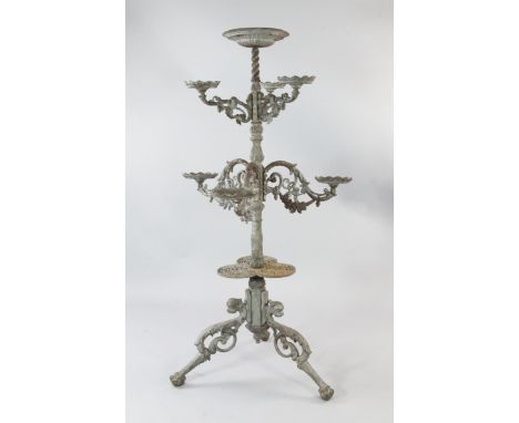 A Victorian style grey painted cast iron plant stand, with central circular bowl over six pierced scrolling branches, each wi