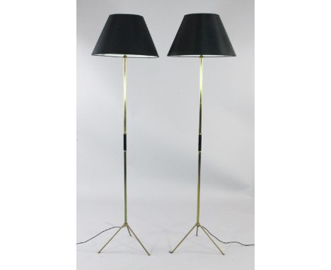 A pair of 20th century tubular brass standard lamps, with spreading tripod feet and black shades, H.5ft 4in. incl. shades
