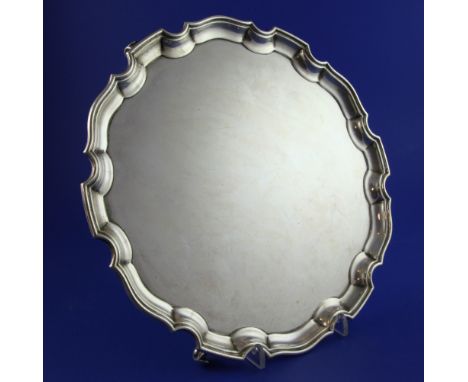 A George V silver salver, of shaped circular form, with pie crust border, on scroll feet, Adie Brothers, Birmingham, 1934, 12