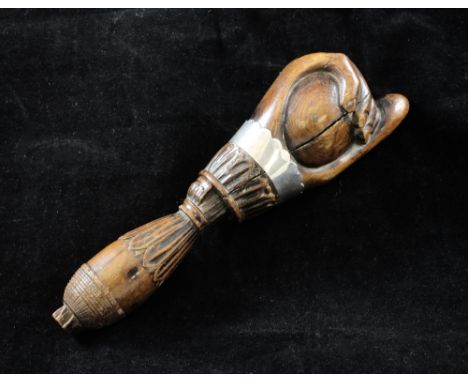 A 19th century carved treen nutcracker, modelled as a hand with unmarked silver ferrule, 6.25in.