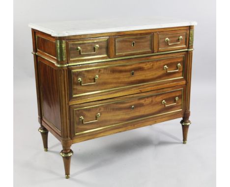 A French Directoire mahogany and brass mounted marble top commode, fitted three long drawers between projecting fluted column