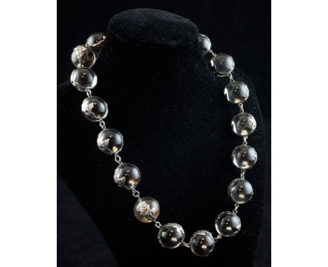 A white metal mounted rock crystal 'pools of light' choker necklace, set with seventeen spherical rock crystal beads with fol