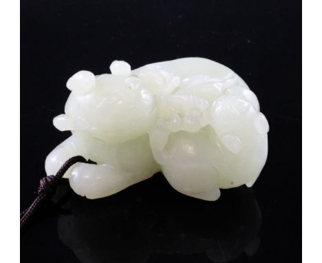 A Chinese pale celadon jade group of two cats, each recumbent and biting a sprig of flowers, the stone of good even tone, 5.6