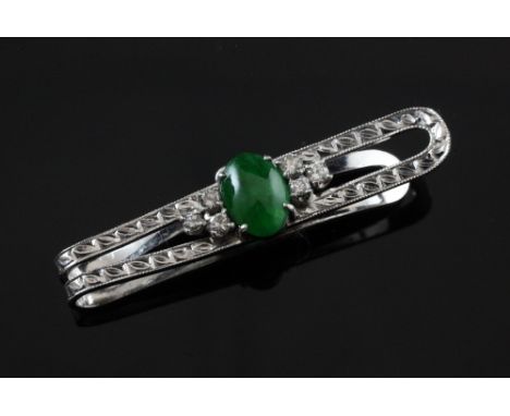 A cabochon jade and diamond set clip, the white metal setting with bright cut engraved decoration and stamped PM, 1.5in.