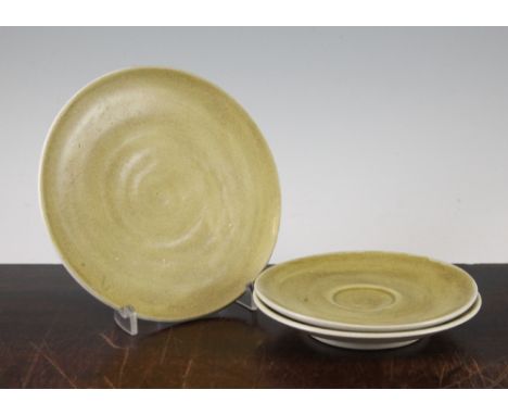 Dame Lucie Rie. A mustard glazed pottery plate and two matching saucers, each with a typical impressed mark to base, 18.2cm a